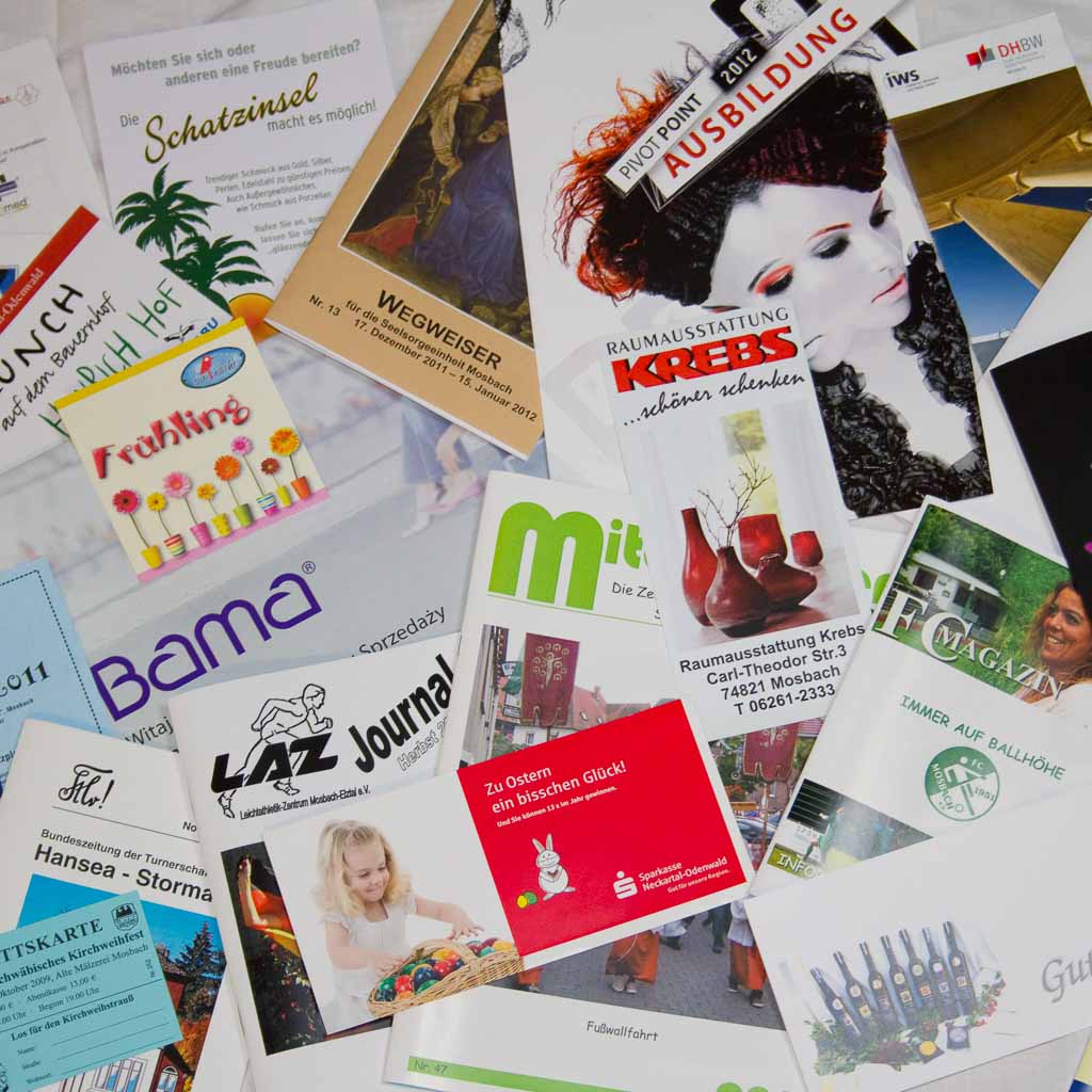 Flyer, Broschüren, Plakate liegen kreuz und quer